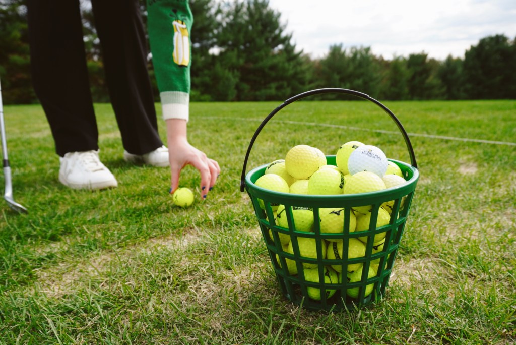 A golfer is placing a ball on the course to tee off. 